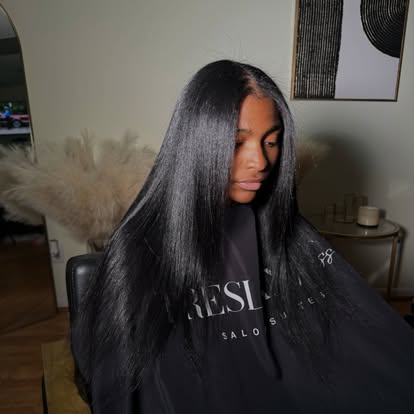 Treslan client with a sleek install, wearing a branded Treslan cape in the salon